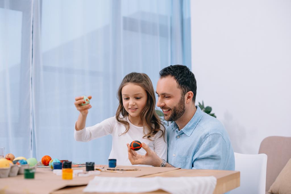 šťastný mladý otec s dcerou malování kraslic - Fotografie, Obrázek
