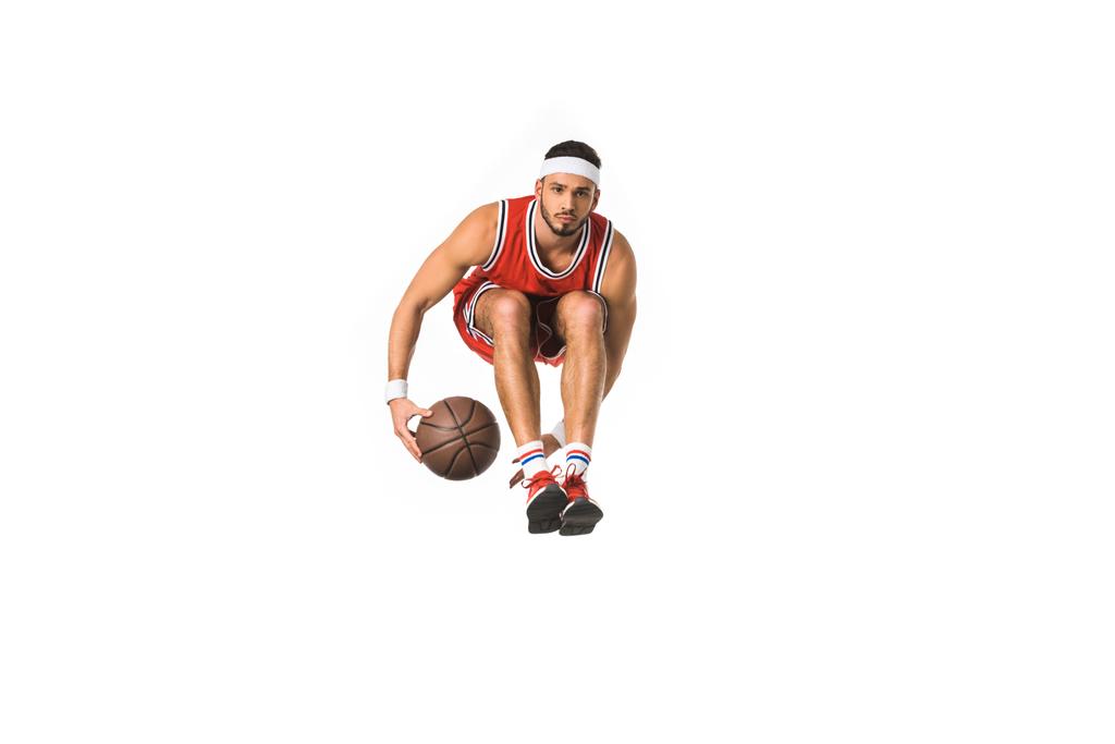 young basketball player with ball jumping and looking at camera isolated on white - Photo, Image