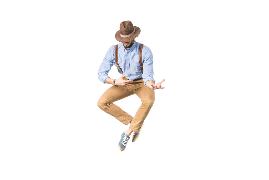 stylish young man in hat jumping and gesturing with hands isolated on white  - Photo, Image
