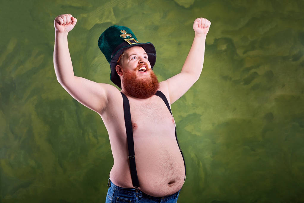 Un hombre gordo y gracioso en el sombrero de San Patricio con el estómago desnudo
. - Foto, imagen