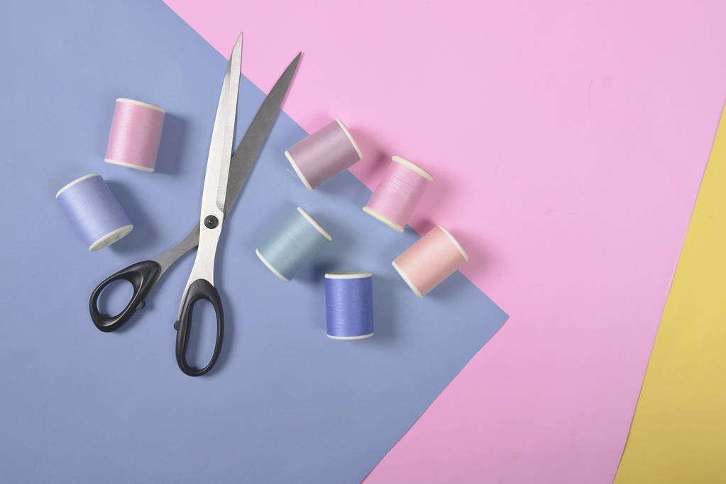 Colocación plana de rollos de hilo de colores y tijeras para coser en dos
  - Foto, Imagen
