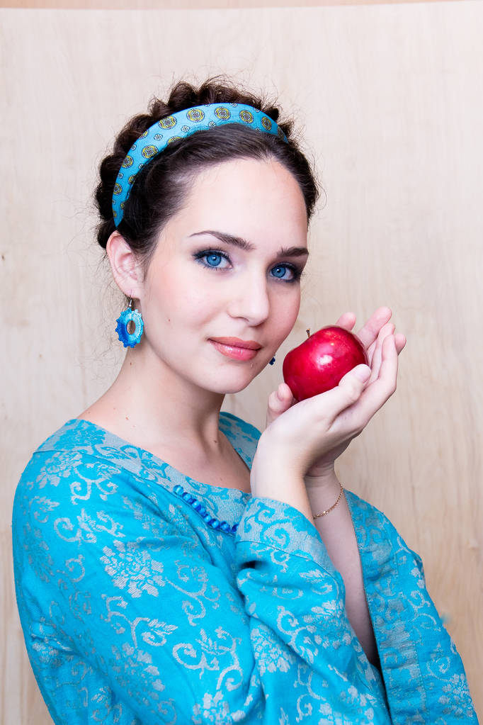 ragazza in un abito blu con mela nel palmo della mano
 - Foto, immagini