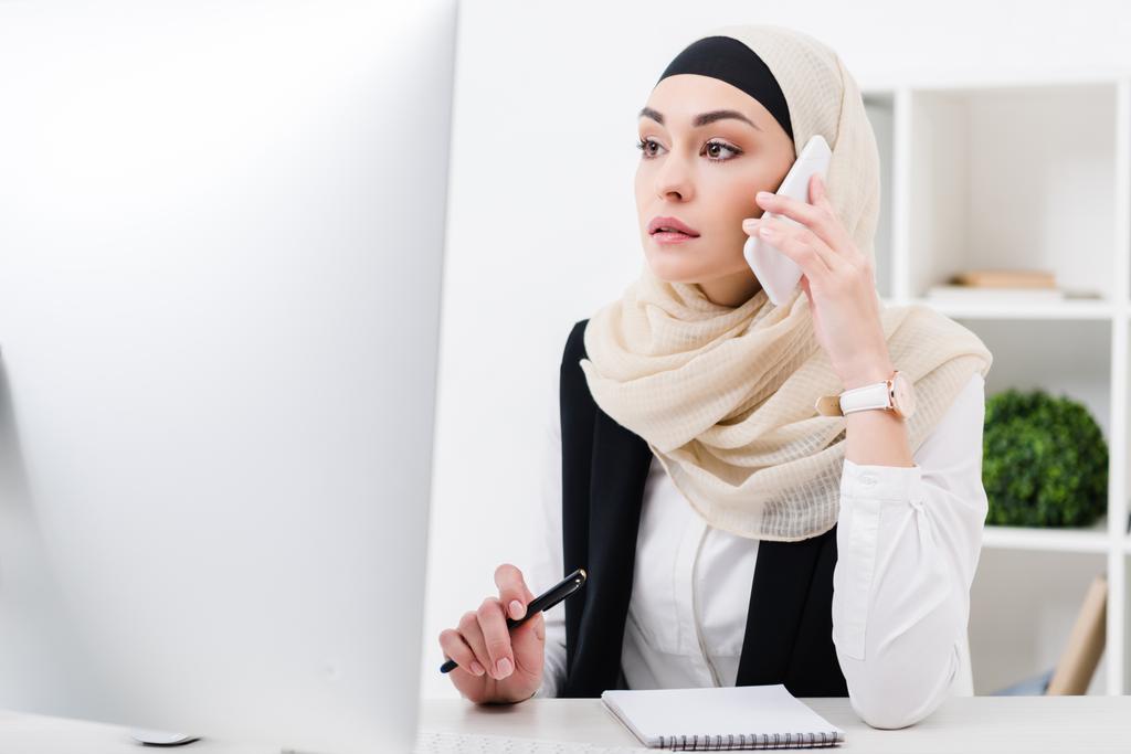 целенаправленная деловая женщина в хиджабе разговаривает на смартфоне на рабочем месте в офисе
 - Фото, изображение