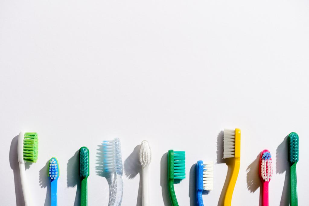 ряд различных зубных щеток, на белом фоне с копировальным пространством
 - Фото, изображение