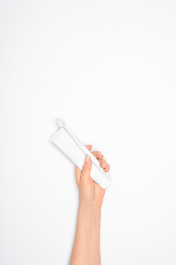 περικοπεί προβολή της γυναίκας κρατώντας την οδοντόβουρτσα και οδοντόκρεμα, απομονώνονται σε λευκό - Φωτογραφία, εικόνα