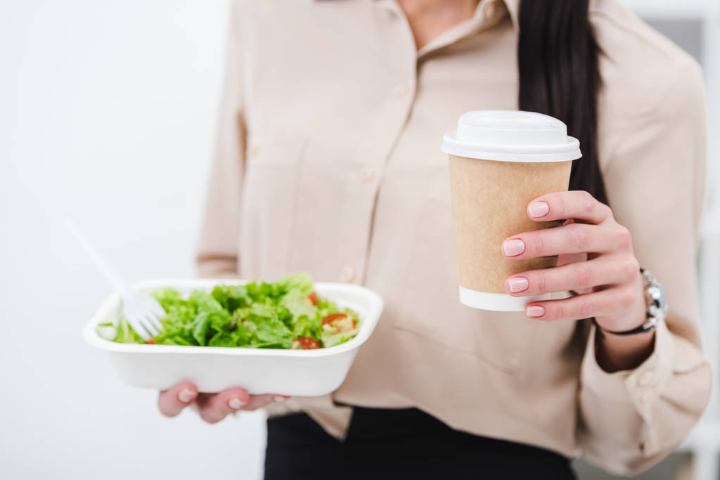 Schnappschuss von Geschäftsfrau mit Essen und Kaffee zum Mitnehmen im Büro - Foto, Bild