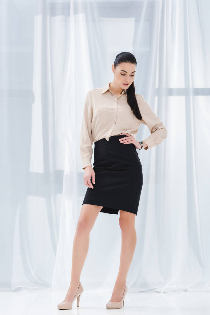 attraktive und stilvolle Geschäftsfrau akimbo in formeller Kleidung im Büro - Foto, Bild