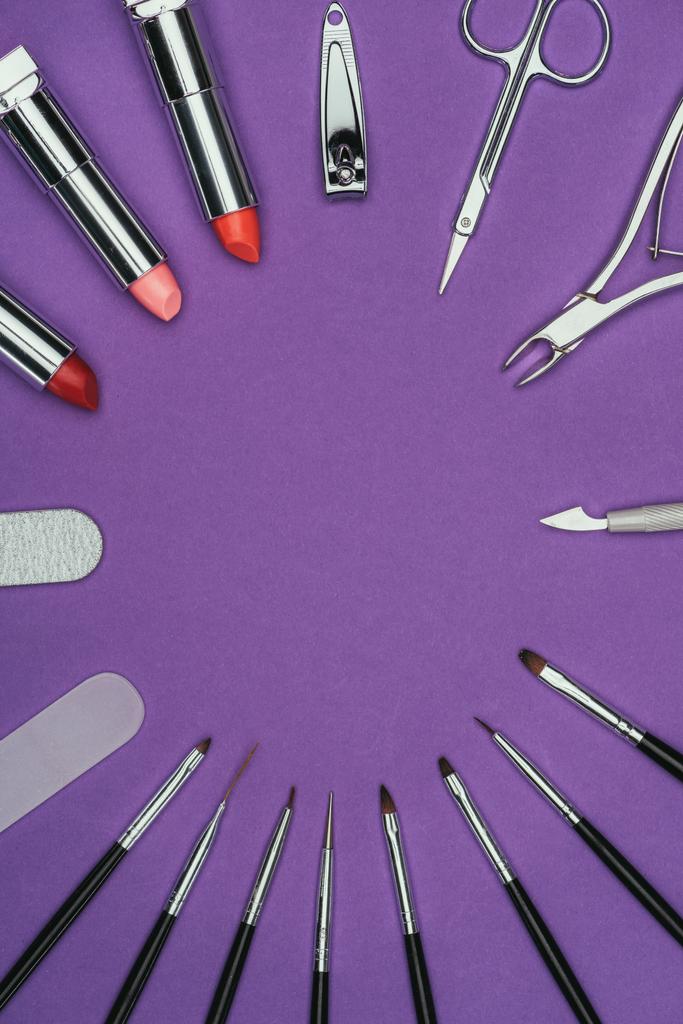 top view of circle of manicure and makeup tools isolated on purple - Photo, Image