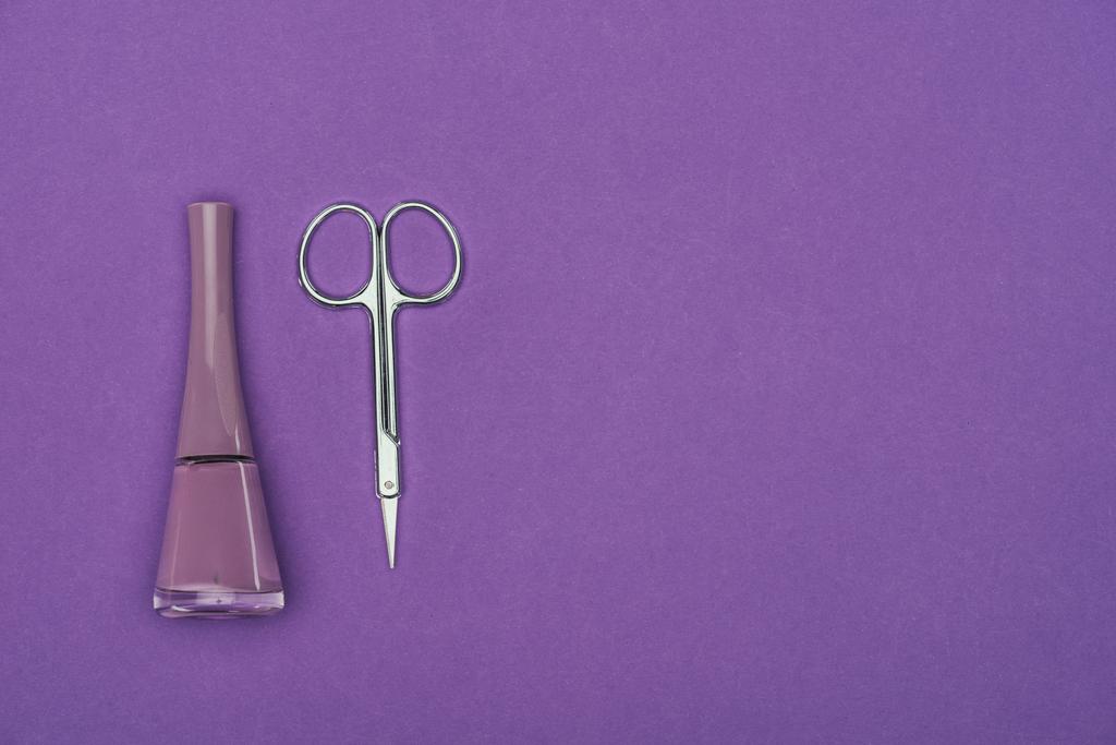 vue du dessus du vernis à ongles et des ciseaux isolés sur violet
 - Photo, image