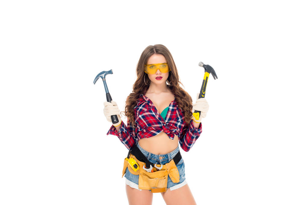 beautiful girl in goggles and gloves with tool belt holding hammers, isolated on white - Photo, Image