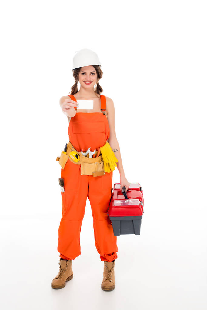 schöne Arbeiterin in Uniform mit Werkzeugkiste und Visitenkarte, isoliert auf weiß - Foto, Bild