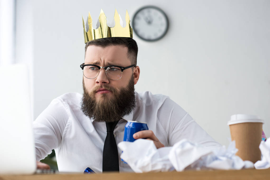 portrait of businessman with paper crown on head and soda drink at workplace in office - Photo, Image