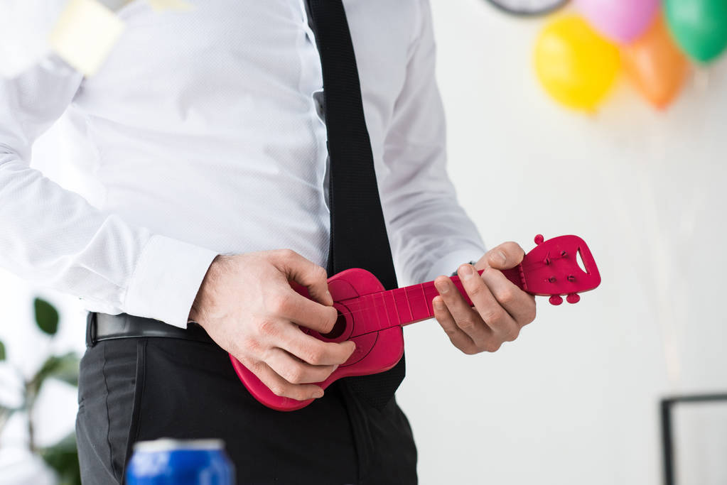 cropped shot of businessman pretending to play toy guitar in office - Photo, Image
