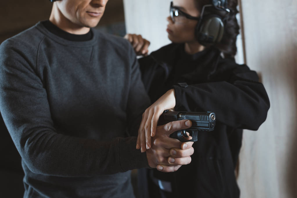 Oříznout obrázek instruktor popisující klienta jak držet zbraň - Fotografie, Obrázek