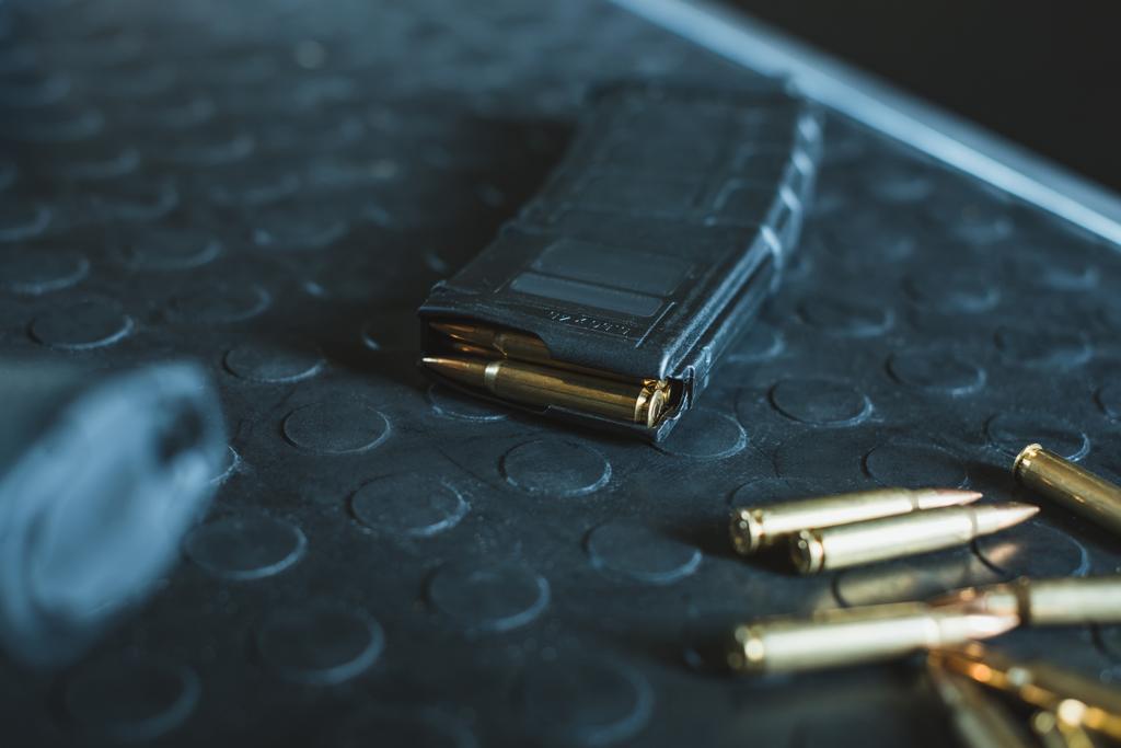 Nahaufnahme von Kugeln und Gewehrmagazin auf dem Tisch - Foto, Bild