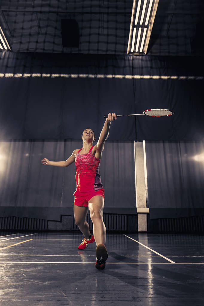 junge Frau spielt Badminton in Turnhalle - Foto, Bild