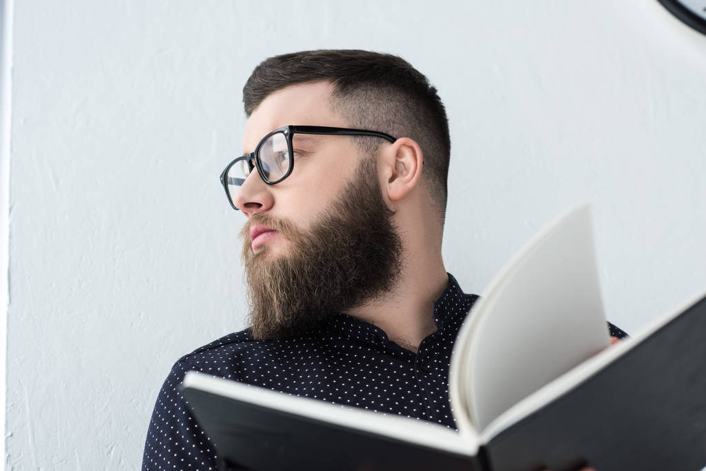 portrait of stylish businessman with notebook looking away - Photo, Image