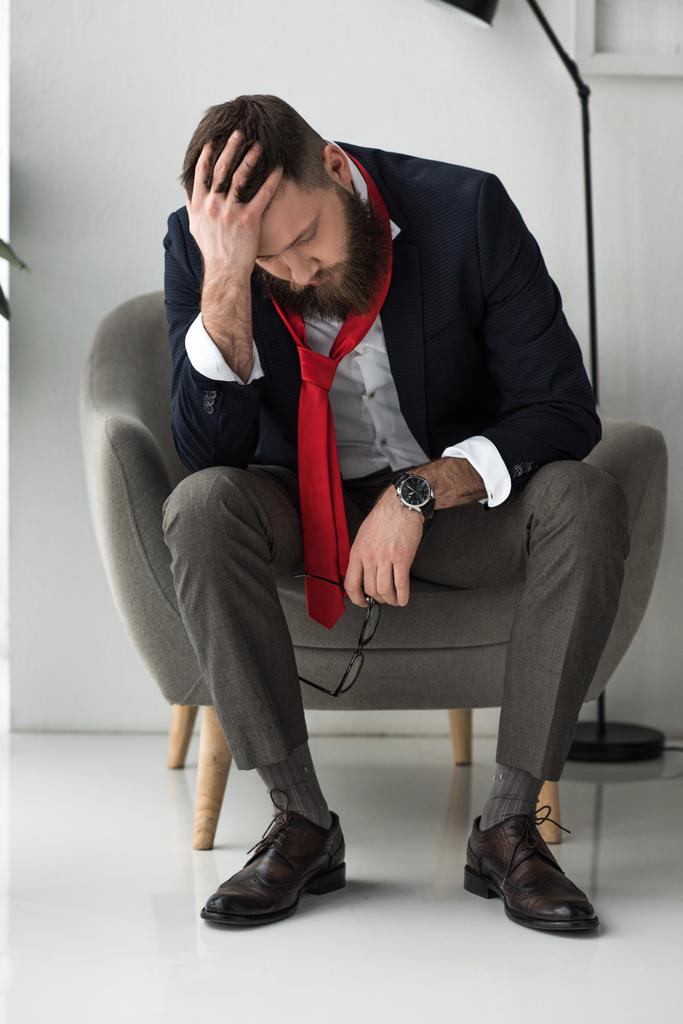 hombre de negocios sobrecargado de trabajo en traje elegante sentado en sillón
 - Foto, Imagen