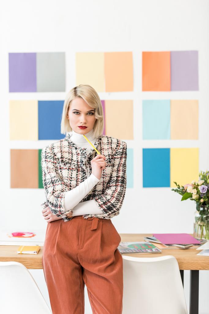 attraktive Redakteurin für Modezeitschriften mit Farbpalette an der Wand im modernen Büro - Foto, Bild