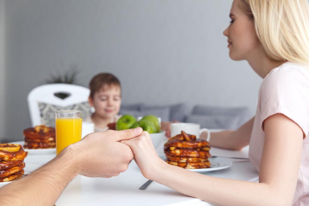 Oříznout záběr mladá rodina se modlí před snídaní - Fotografie, Obrázek