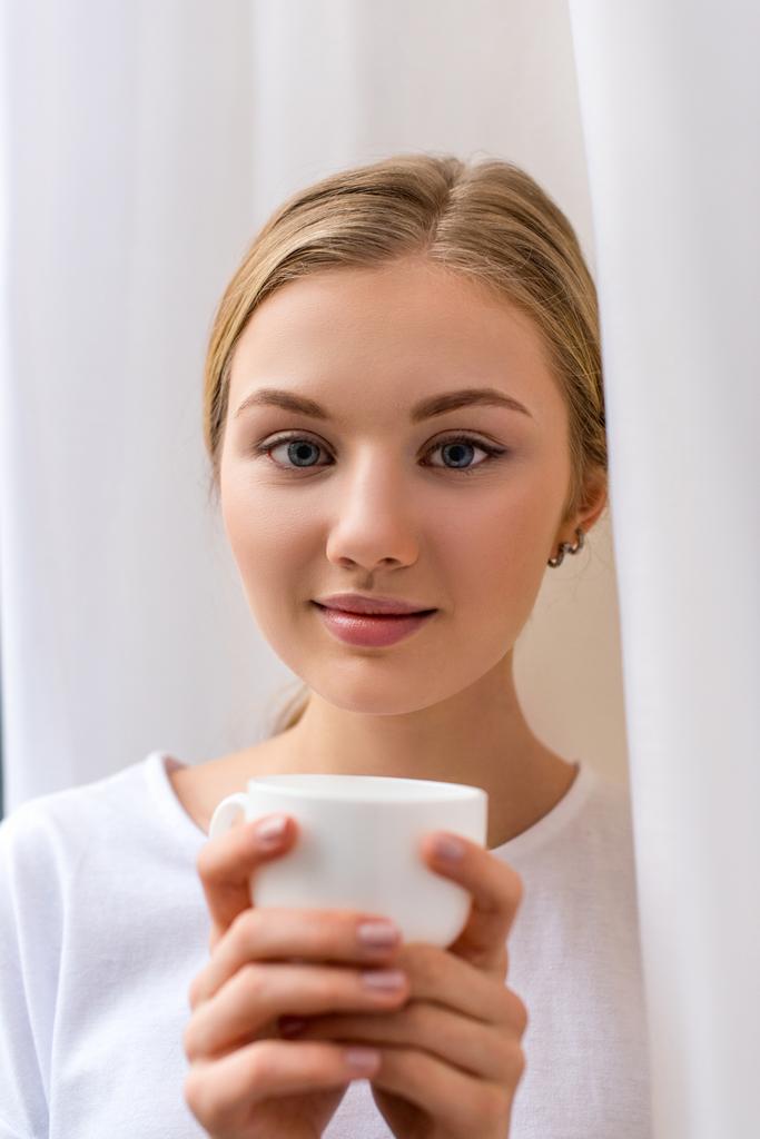 schöne junge Frau mit einer Tasse Kaffee - Foto, Bild