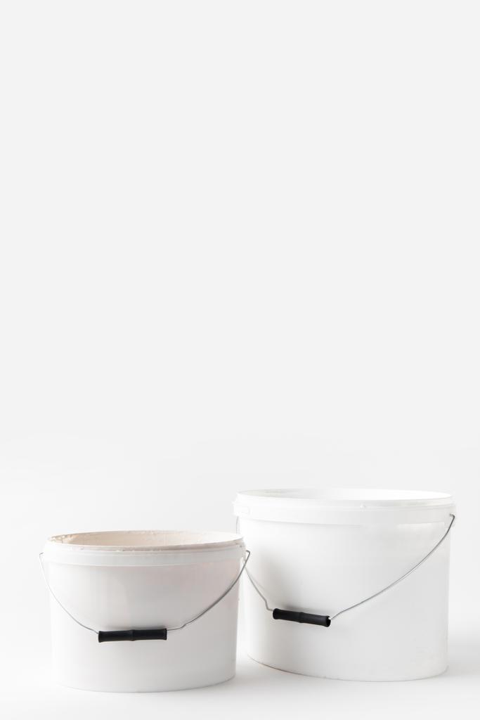 dois baldes brancos de plástico com tintas isoladas em branco
 - Foto, Imagem