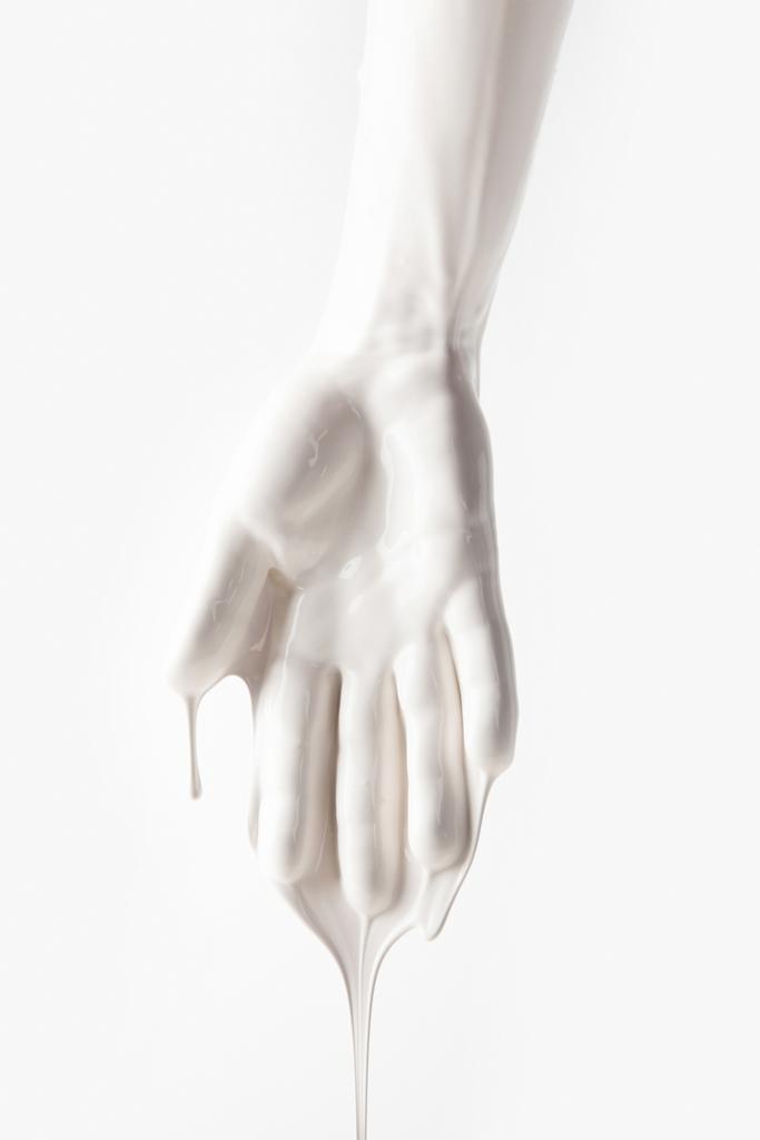 abgeschnittenes Bild des weiblichen Arms in weißer tropfender Farbe isoliert auf weiss - Foto, Bild