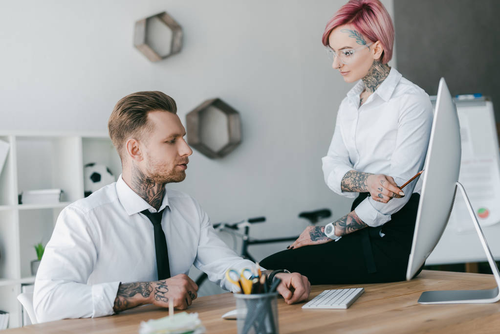 young businessman and businesswoman with tattoos working together in office - Photo, Image