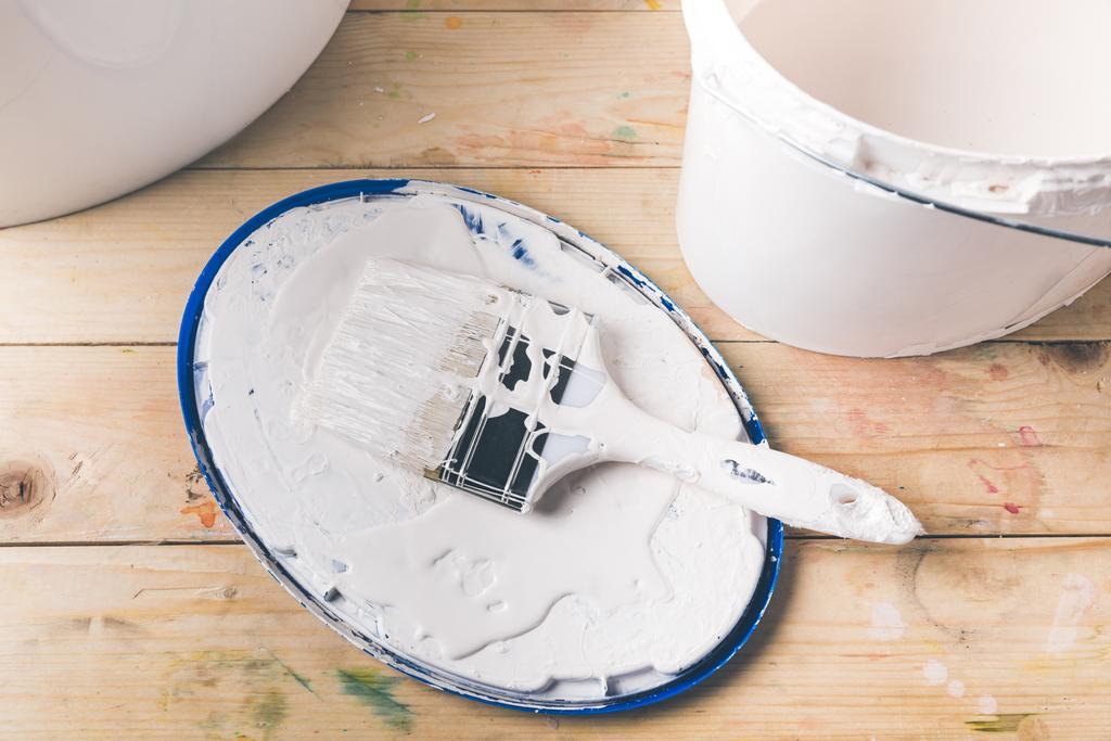brush in white paint on cover from bucket - Photo, Image