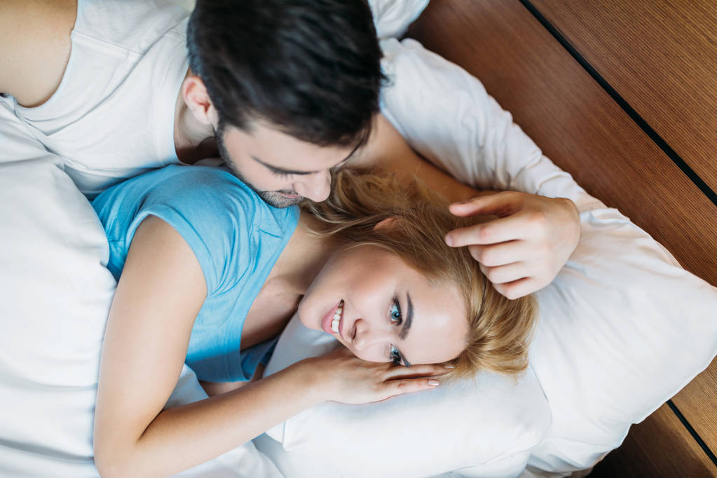 彼氏の朝ベッドのガール フレンドの髪に触れるのオーバー ヘッド ビュー - 写真・画像