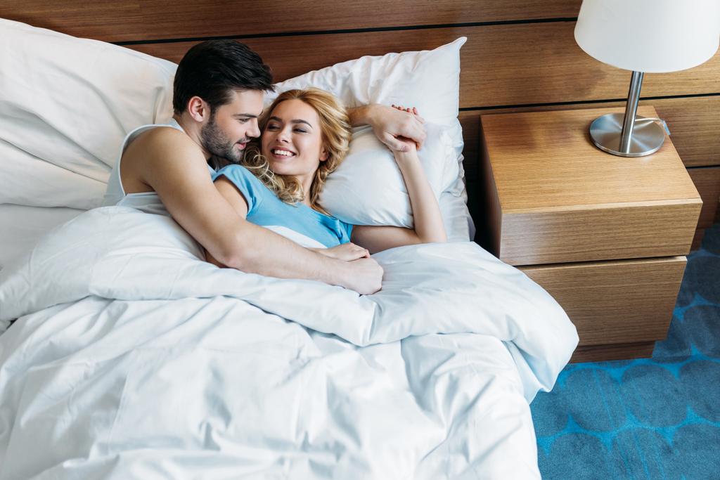 novio abrazando novia en la cama en la mañana
 - Foto, Imagen