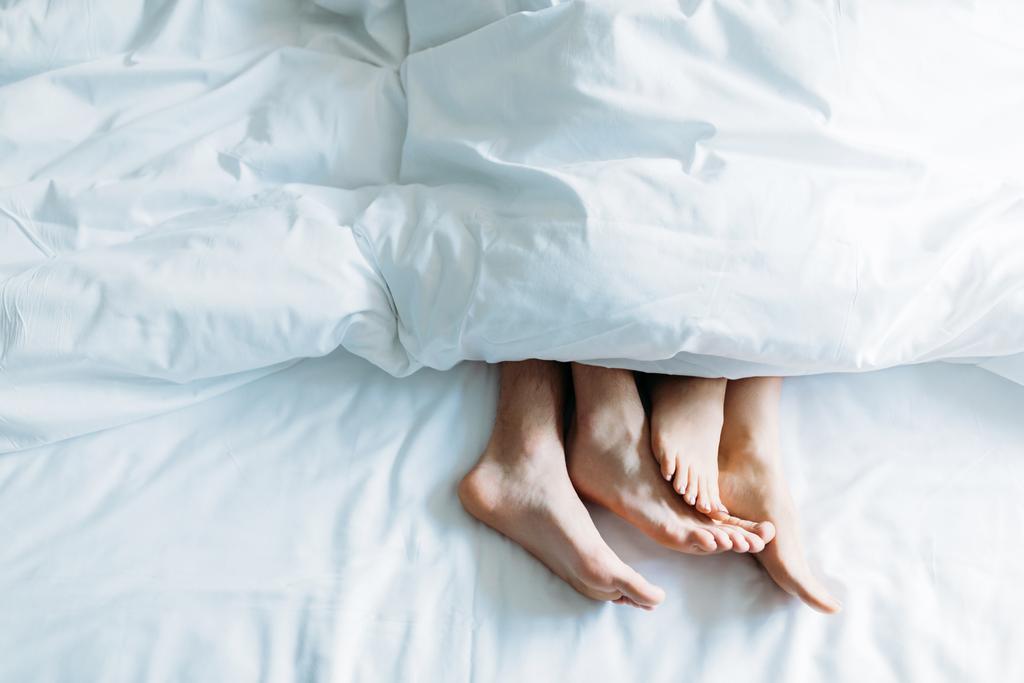 rajattu kuva poikaystävä ja tyttöystävä makaa sängyssä peiton alla
 - Valokuva, kuva