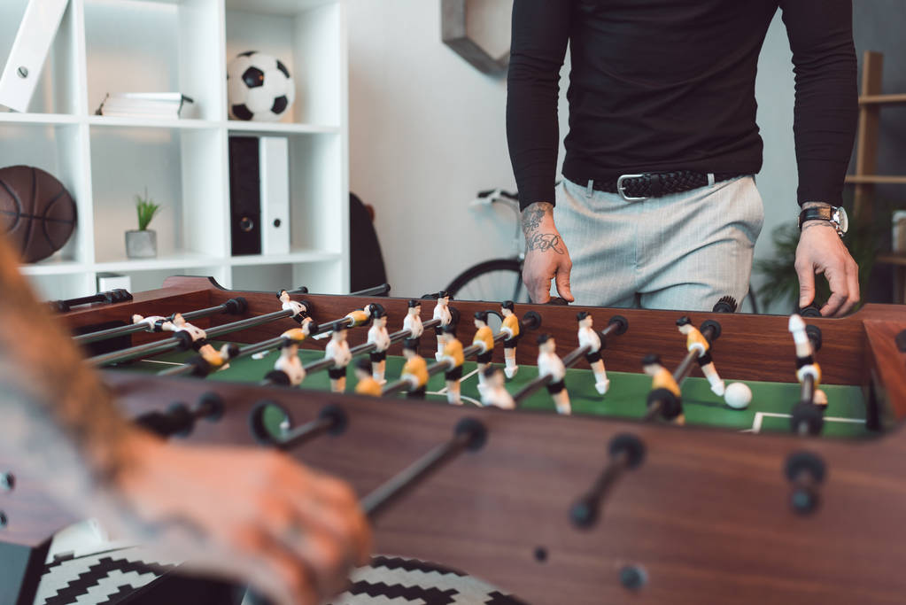事務所のテーブル サッカーを再生する人々 のショットをトリミング - 写真・画像