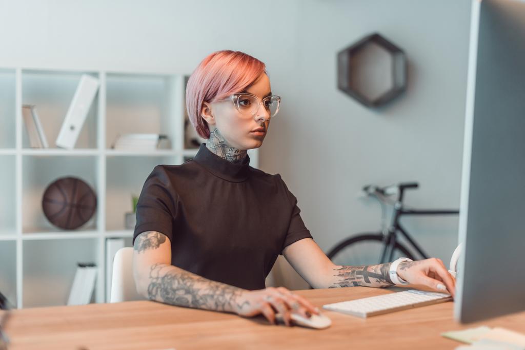 giovane donna d'affari in occhiali utilizzando il computer desktop sul posto di lavoro
 - Foto, immagini