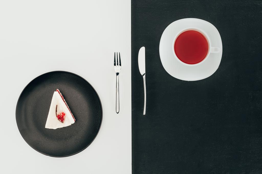 top view of piece of cake on plate, cutlery and cup of tea - Photo, Image