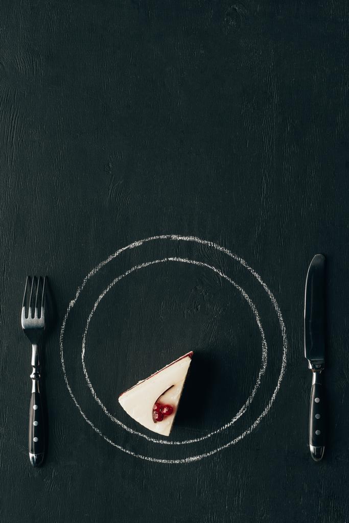 bovenaanzicht van een fluitje van een cent en bestek op zwart tafelblad - Foto, afbeelding