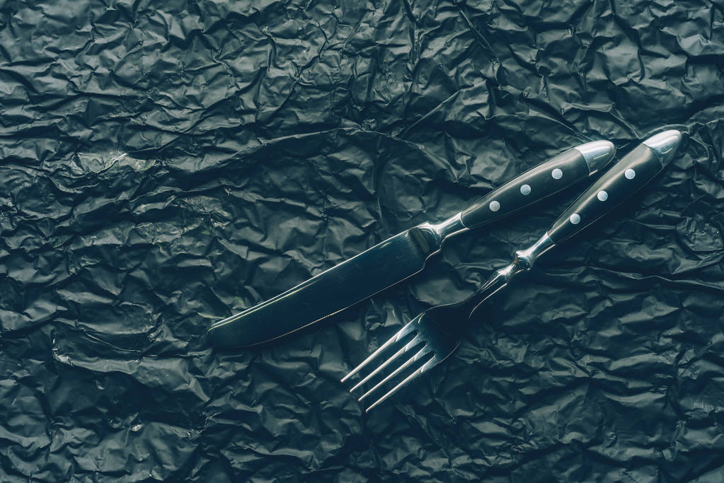 close up view steel fork and knife on dark textured surface - Photo, Image