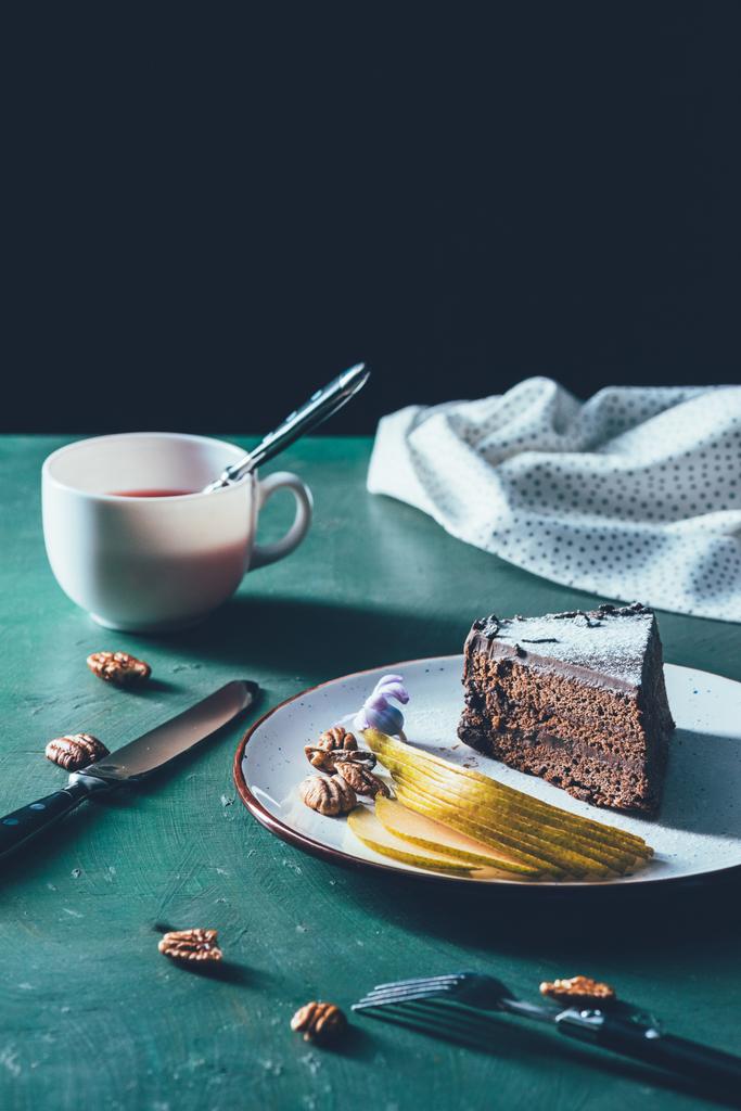 pasta plaka üzerinde düzenlenen armut ile görünümünü ve masa üzerinde çay kapatır - Fotoğraf, Görsel