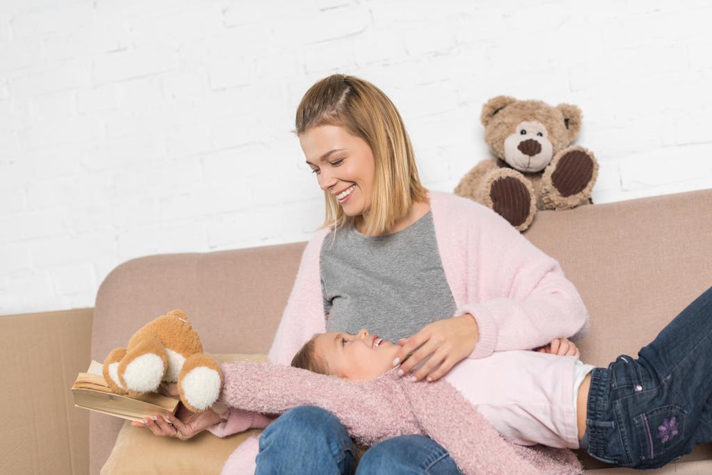 щаслива мати і дочка розважаються разом на дивані
 - Фото, зображення