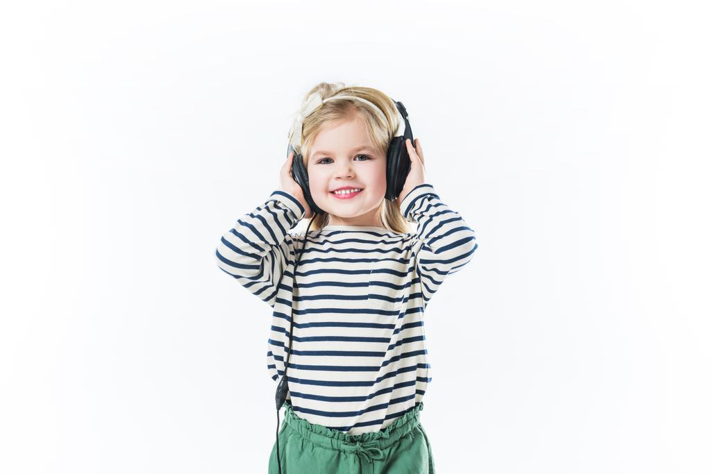 красивый маленький ребенок слушает музыку с наушниками изолированы на белом
 - Фото, изображение