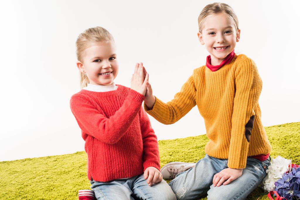 little sisters giving high five white sitting on floor together isolated on white - Photo, Image