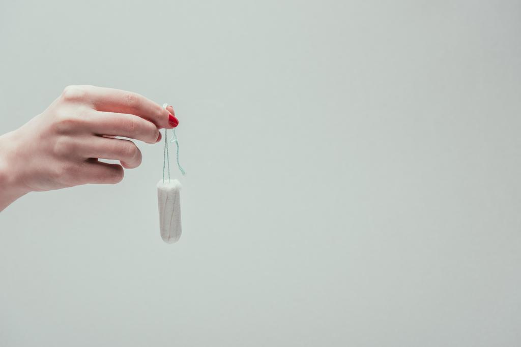 обрізаний знімок жінки, що тримає тампон в руці ізольований на сірому
 - Фото, зображення