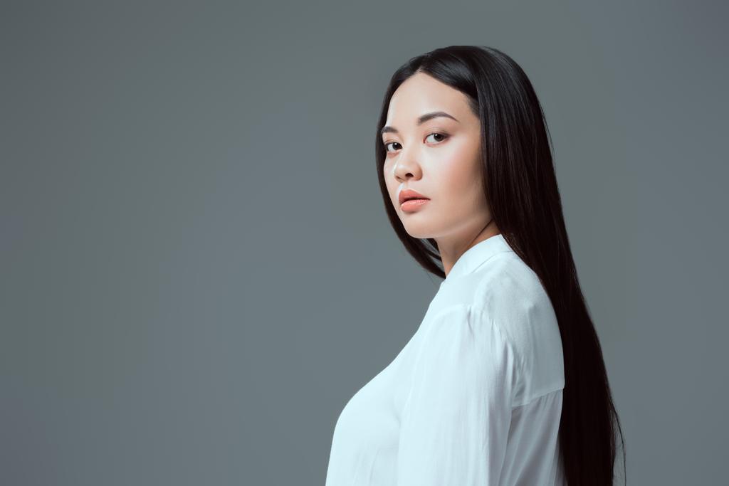 Porträt der schönen asiatischen Mädchen Blick auf Kamera isoliert auf grau - Foto, Bild