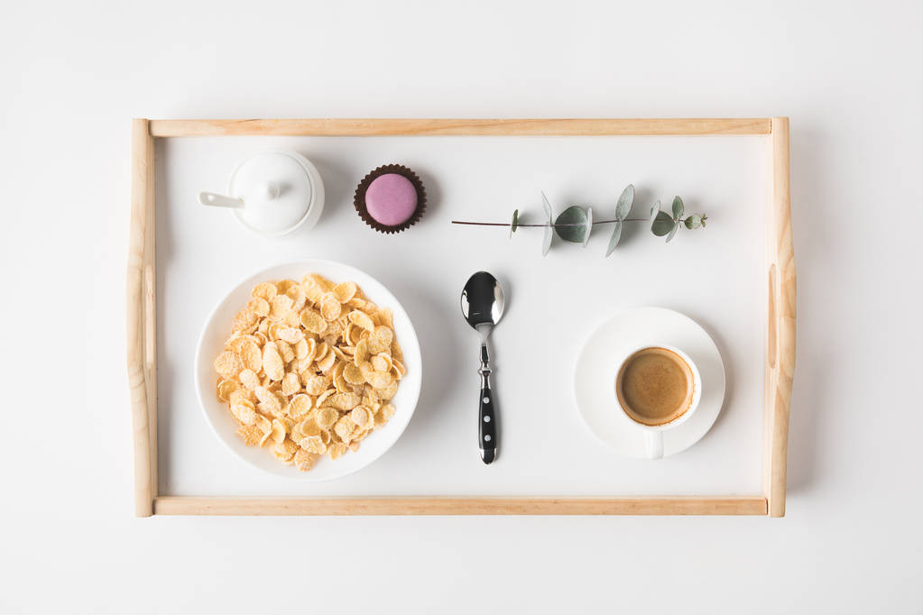 vista superior do café da manhã com flocos de cortiça na tigela e xícara de café na bandeja na superfície branca
 - Foto, Imagem