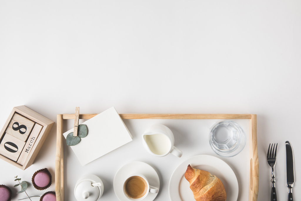 επίπεδη lay με Κύπελλο Καφές και κρουασάν για πρωινό σε δίσκο σε λευκά επιτραπέζια - Φωτογραφία, εικόνα