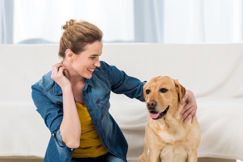 femme caressant son chien labrador à la maison
 - Photo, image