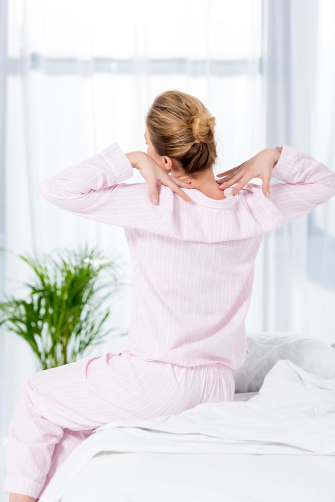 Achteraanzicht van vrouw stretching na wake up - Foto, afbeelding