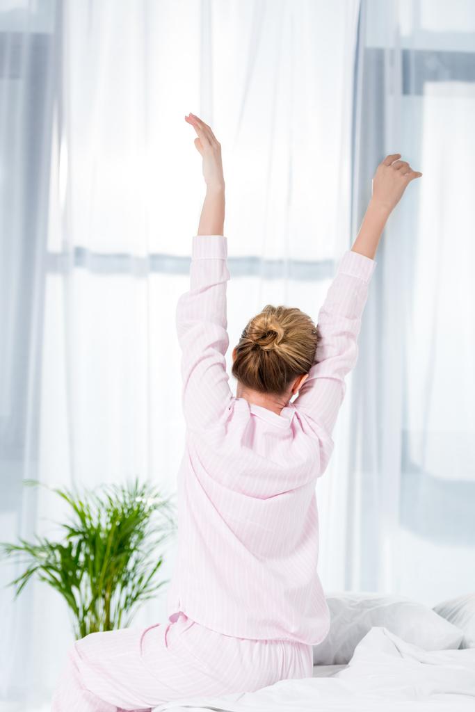 rear view of woman stretching after wake up - Photo, Image