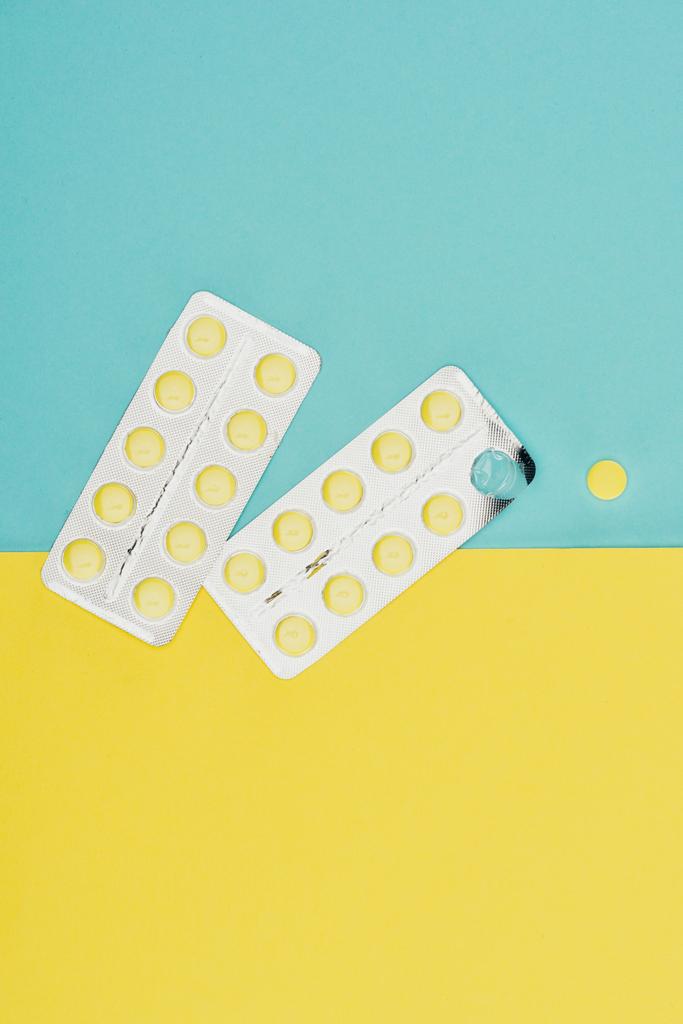 a kék és a sárga háttér elszigetelt gyógyszerek felülnézet - Fotó, kép