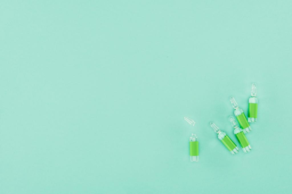 vista superior de ampollas dispuestas aisladas en verde
 - Foto, imagen
